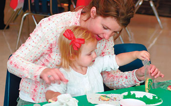 Reese Verhaeghe, 19 months, makes a Christmas cookie